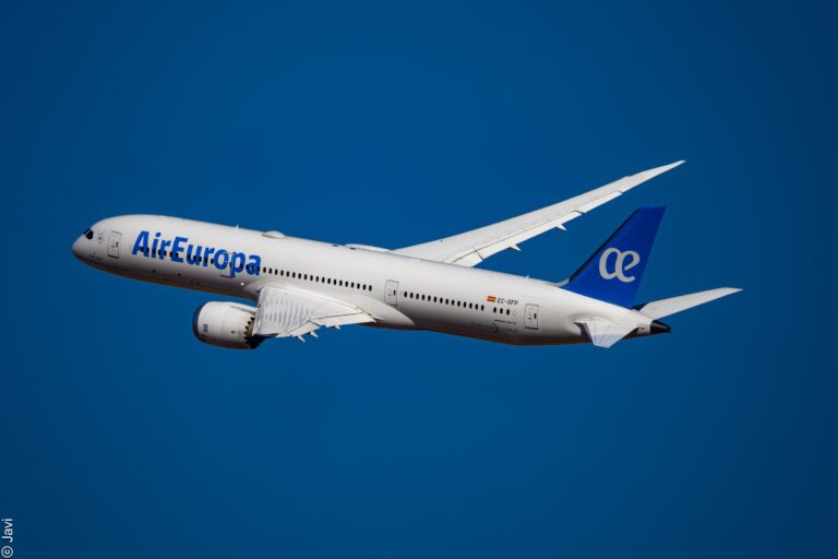 Air Europa airplane flying in clear blue sky, representing global air travel and airline services.