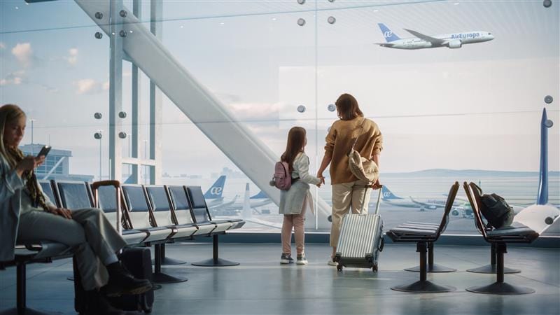 Modern airport lounge with travelers waiting and airplane taking off in the background at Globalia Corp.
