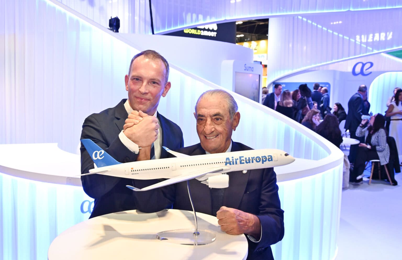 Air Europa model airplane at aviation event, two executives showcasing airline innovation and branding.