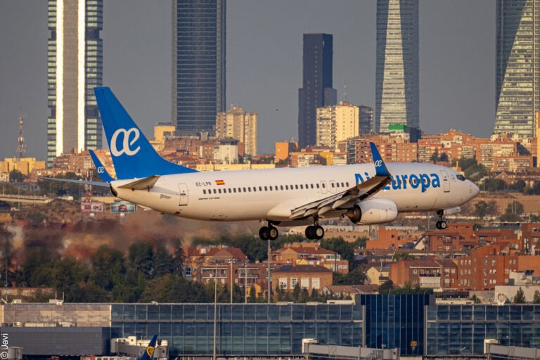 1. Airplane with Globalia branding landing over urban cityscape, commercial aviation, flight.