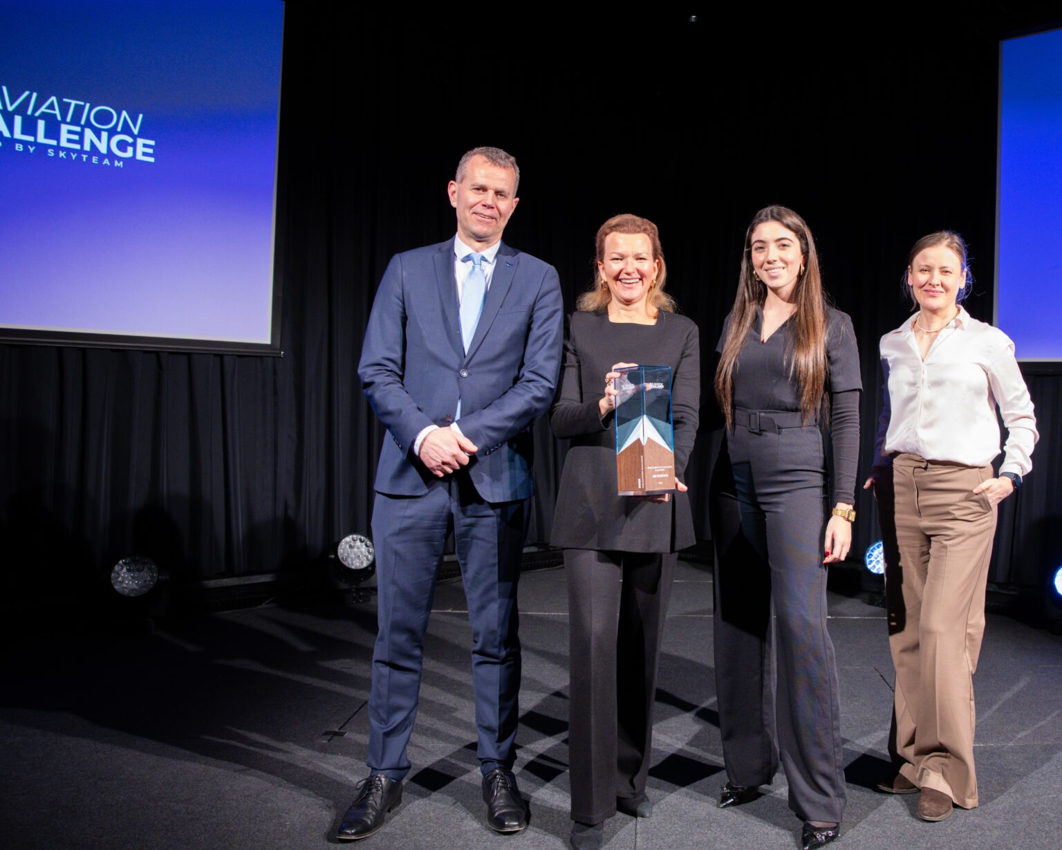 Globalia Corp team receiving an award at a corporate event on stage.
